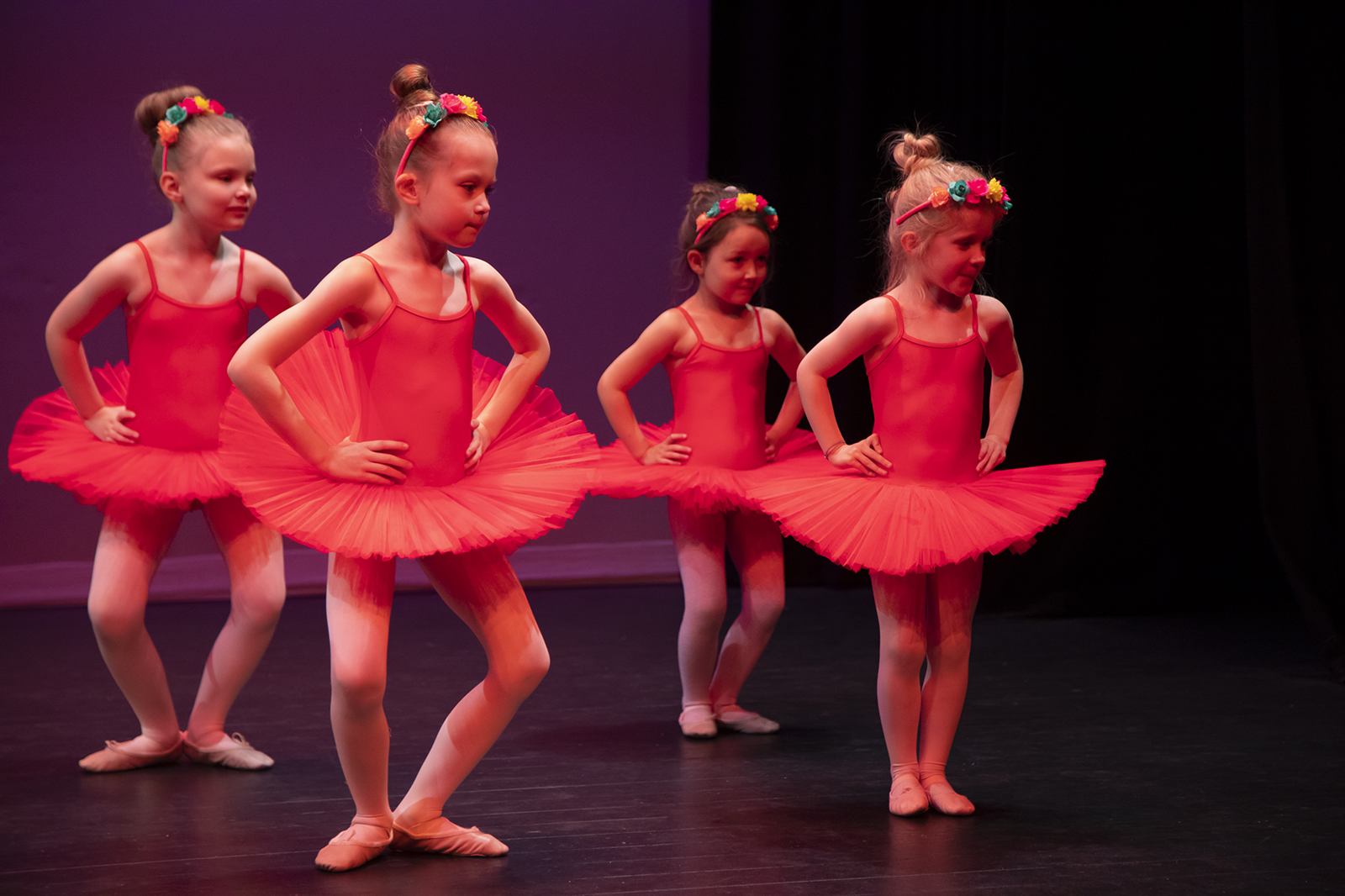 Young ballerinas in red tutus performing at the annual showcase